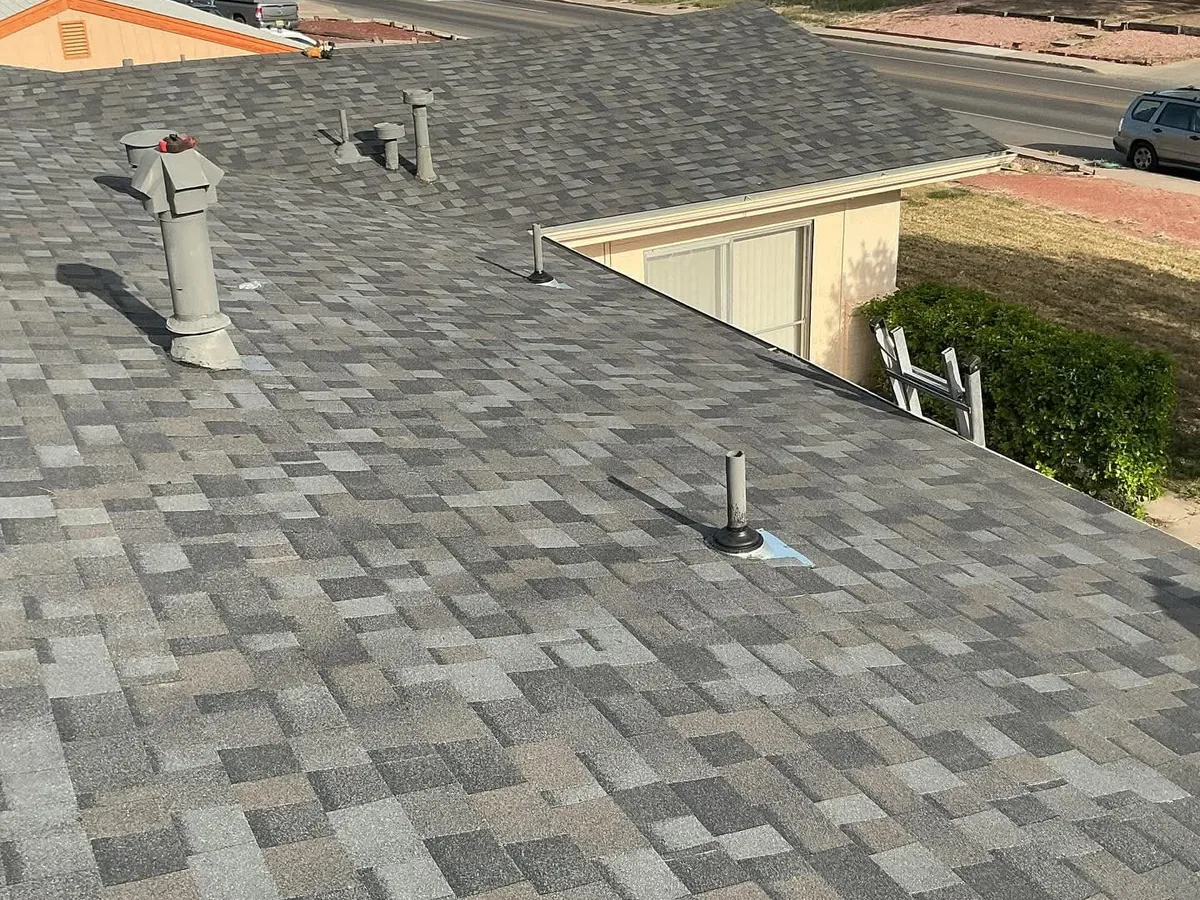 Gray architectural shingle roof with vent pipes and roof jacks