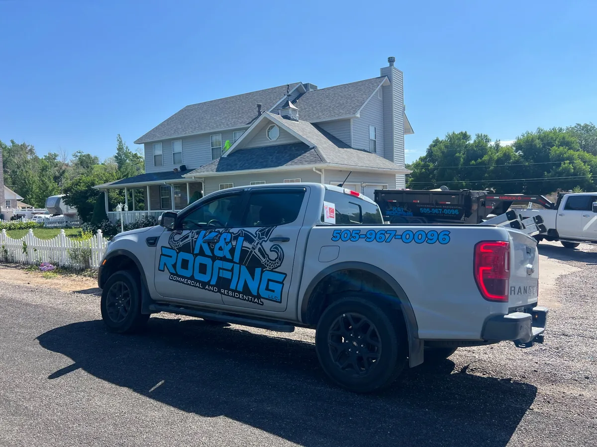 Roofing service truck parked in front of a two story home